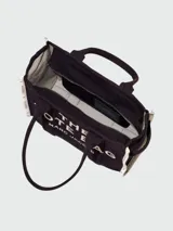 Bolso tote grande Marc Jacobs color beige con estampado del logo de la marca en negro. Tiene doble asa de mano y laterales con inscripción de la marca.