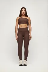 Top deportivo negro de un solo hombro, con textura acanalada y calce ajustado.