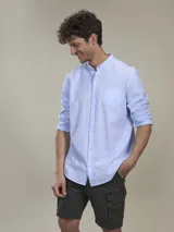 Camisa blanca de lino con cuello mao, manga larga con puños abotonados y bolsillo en el pecho.