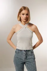 Top cropped gris metalizado con cuello halter y detalle de studs.