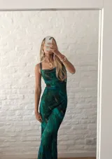 Vestido largo ajustado al cuerpo, confeccionado en microtul estampado con diseño abstracto en tonos verde, azul y marrón. Tiene breteles finos y forro interior opaco.