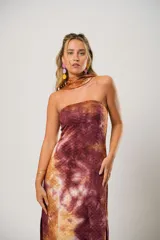 Vestido largo marrón con estampado batik, escote recto, tajo lateral y lazo para atar al cuello.