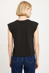 Remera blanca de algodón con cuello redondo y mangas cortas con hombreras.
