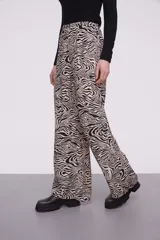 Pantalón de viscosa con estampado abstracto en tonos beige y negro, de corte palazzo y cintura con lazo ajustable.