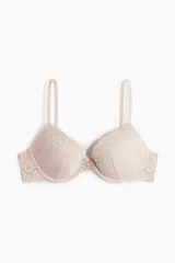 Soutien push-up color rosa pálido con encaje floral en las copas y contorno. Tiene aros, breteles ajustables y copas acolchadas. Cierre de corchetes en la espalda.