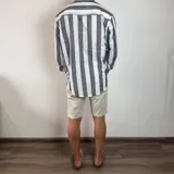 Camisa celeste y blanca a rayas verticales, de lino, con cuello mao y mangas largas con puños.