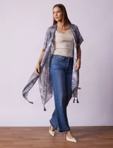 Kimono tejido con estampado abstracto en tonos grises y blancos, con mangas cortas y terminación de ruedo con borlas negras.