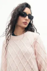 Sweater rosa pastel de tejido de punto con estructura en forma de rombos y apliques de perlas.