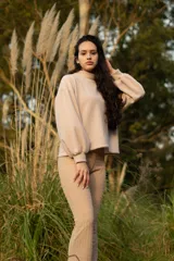 Buzo color beige de cuello alto y mangas abullonadas.