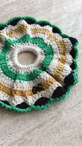 Gomita de pelo tejida al crochet con hilo de algodón a rayas en tonos rosa y violeta, con borde gris.