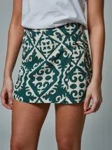 Falda short con estampado geométrico en tonos verde oscuro y beige.