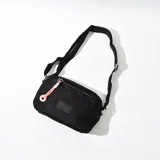 Bandolera negra de tela con correa larga regulable y cierre superior.