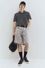 Remera polo gris de piqué de algodón, de manga corta, con cuello clásico, tapeta de botones, remate acanalado en cuello y mangas, bajo recto con aberturas laterales y corte estándar.