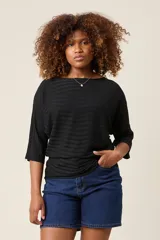 Blusa color rosa claro de hilo con textura acanalada horizontal, escote bote y mangas 3/4. Corte holgado.