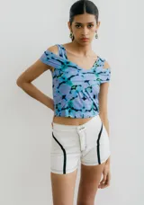Top de jersey con estampado abstracto en tonos celeste, azul y negro. Diseño con hombros descubiertos y corte cruzado en el frente.