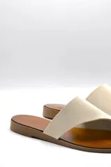 Sandalias bajas color beige con capellada cruzada de neopreno y plantilla de cuero.