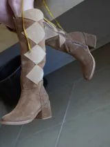 Botas altas de gamuza color marrón con diseño geométrico en tonos beige y marrón. Cierre lateral con cremallera y tacón cuadrado. Diseño exclusivo.
