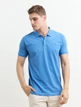 Chomba celeste con estampado de lunares blancos, cuello clásico y mangas cortas.