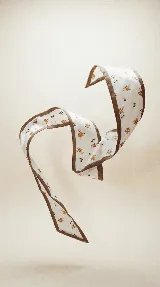 Pañuelo largo y estrecho de seda con estampado abstracto en tonos azules y blancos, con borde blanco y ribete marrón.