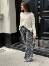 Sweater color beige con cuello redondo y diseño de trenzas en relieve.