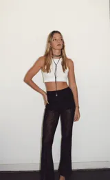 Pantalón de encaje negro con cintura elástica y corte acampanado.