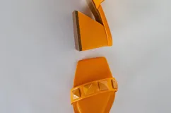 Sandalias de tacón fucsia con dos tiras con tachas piramidales y tacón cuadrado.