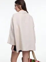 Camisa de lino color negro con silueta amplia y mangas 3/4. Diseño con tiras de color blanco en contraste en la cartera, mangas y cuerpo. Tiene tajos laterales y ruedo irregular en el frente.