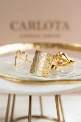 Anillo cuadrado en acero quirúrgico con baño de oro de 18k y textura labrada. Diseño liviano y cómodo, hipoalergénico.