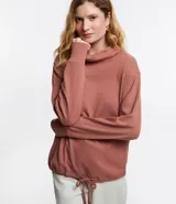 Polera hecha en tela canalé con tacto peluche, color ladrillo, con cuello alto, mangas largas y lazo en el bajo.