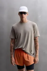 Camiseta deportiva color beige confeccionada en tejido con estructura, ligero y elástico en todas direcciones. Tiene cuello redondo, manga corta, costuras planas y logo estampado en el bajo.