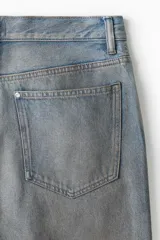 Pantalón de jean celeste con efecto lavado, corte holgado de cadera a bajo con piernas redondeadas extraanchas y pliegues al tobillo.