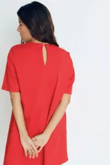 Vestido corto rojo con cuello redondo y manga corta. Presenta detalle de botones dorados en el hombro.