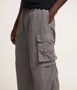 Pantalón paper touch color verde militar, con bolsillos laterales, cintura elástica y cordón de ajuste. Se convierte en bermuda gracias a un cierre a la altura de la rodilla.