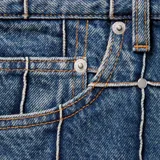 Pantalón de jean azul con diseño de cuadrícula con tachas en las costuras, corte holgado.