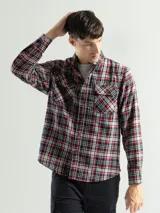 Camisa de franela a cuadros rojos, negros y grises, de manga larga y corte clásico, con dos bolsillos en el pecho.