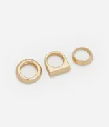 Set de tres anillos dorados con diferentes diseños geométricos.