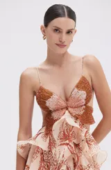 Vestido largo de fiesta color beige con estampado de hojas en tonos marrones, con corpiño bordado con cuentas y falda con volados.