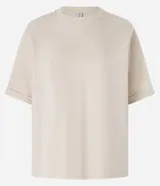 Remera de manga corta color crema, con cuello redondo y corte oversized.