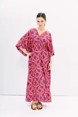 Vestido largo de viscosa estampada en tonos naranja y violeta. Tiene mangas al codo, calce holgado y recorte en la cintura con frunces.
