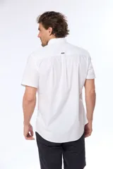 Camisa azul marino lisa de manga corta con cuello abotonado, cierre frontal con botones y bolsillo en el pecho. Confeccionada en algodón.