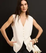 Chaleco largo color crema, con botones delanteros y lazo en la espalda.