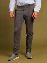 Pantalón de vestir color beige con pinzas, bolsillos laterales y traseros. El ruedo tiene un pequeño corte lateral.