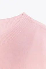 Top de punto color rosa, de cuello redondo y manga corta ancha.