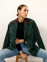 Blazer verde pino de gamuza con cuello marrón chocolate, bolsillos con solapa y botones color hueso.