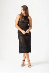 Vestido midi negro de tejido crochet calado, con cuello halter y corte ajustado.