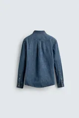 Camisa relaxed fit confeccionada en denim de algodón con cuello solapa, manga larga con puño abotonado, efecto lavado medio y cierre frontal con botones.