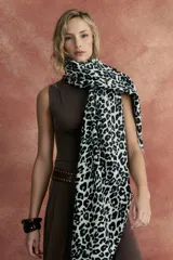 Bufanda rectangular de tejido suave color crudo con estampado animal print de leopardo en negro.