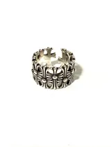 Anillo plateado con diseño de cruces caladas y acabado envejecido.