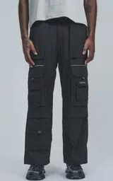 Pantalón técnico negro multipocket con cintura elástica, detalles reflectivos y silueta oversize.