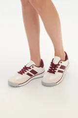 Zapatillas bajas color beige y blanco con detalles en verde agua.